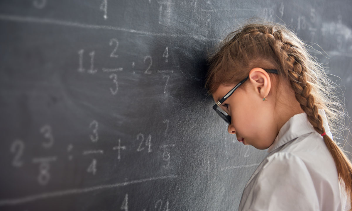 Kid struggling with math at the chalkboard.