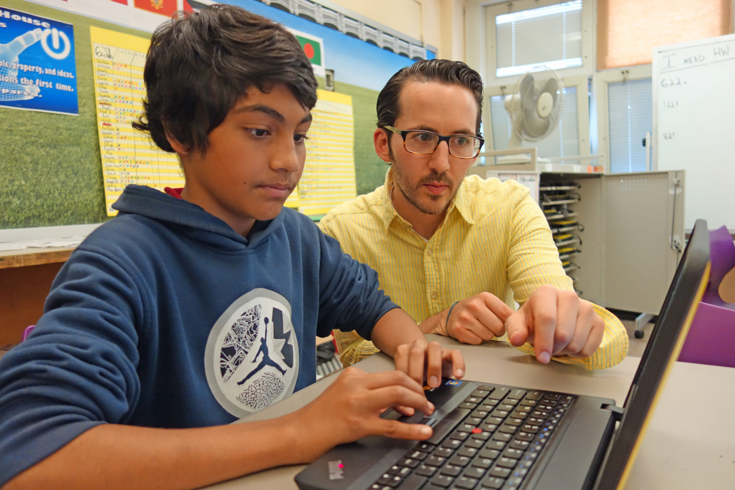 Teacher and Student looking at a laptop computer